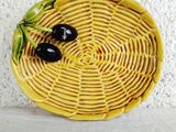 a yellow plate with two black olives on it