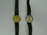a couple of watches sitting next to each other on top of a table