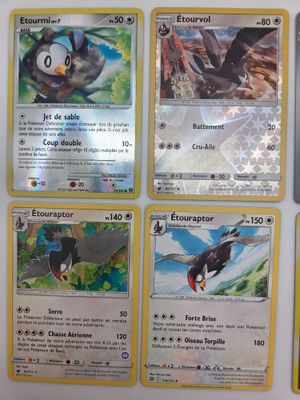 Plusieurs cartes Pokémon sont accrochées au mur d'une pièce.