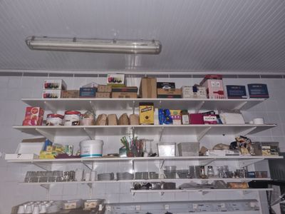 de nombreuses étagères sur lesquelles sont disposés divers objets dans la cuisine