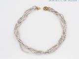 necklace made of glass beads with a gold clasp on a white background