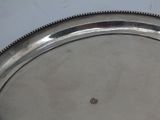 a silver tray with a beaded edge sitting on a table
