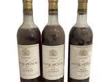 trois bouteilles de vin posées les unes à côté des autres sur une surface blanche