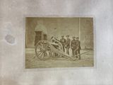 an old photo of a group of men standing next to a cannon