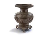 a brown vase that is on a stand on a white surface