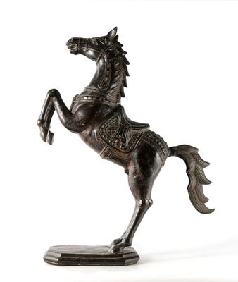 statue en bronze représentant un cheval avec une selle posée sur ses pattes arrière