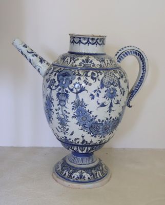a blue and white vase with a handle on a table
