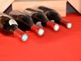 several bottles of wine are lined up on a red table cloth