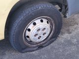 a yellow van with a flat tire on the street