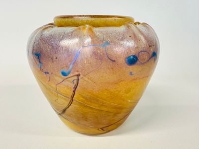 a yellow vase with blue designs on it on a white surface