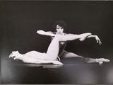 black and white photograph of a woman doing a split on the floor