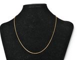a black mannequin torso with a gold chain on it