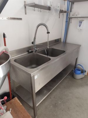 une cuisine équipée d'un évier et d'un plan de travail avec un robinet
