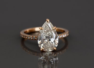 une bague de fiançailles sertie d'un diamant en forme de poire entouré de petits diamants