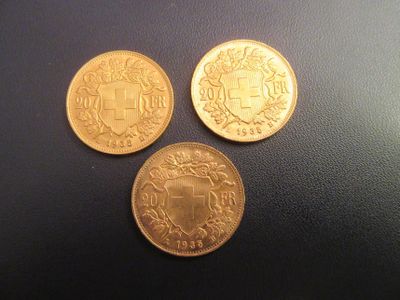 trois pièces d'or posées les unes à côté des autres sur une table