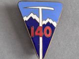 une image représentant un pin's orné d'un triangle bleu et blanc sur lequel figure le chiffre 140