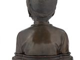 statue of a woman sitting on a pedestal with her back to the camera