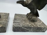two statues of a bird that are on top of a stone block