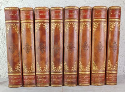 six livres anciens reliés en cuir alignés sur une étagère