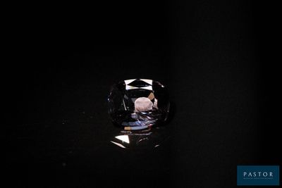 un gros plan d'une bague dans l'obscurité, éclairée par une source lumineuse