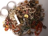 a pile of assorted jewelry on a white surface