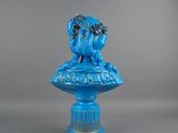 an image of a blue statue of a woman sitting on a pedestal