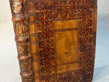 an old book with a brown cover sitting on top of a table