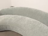 a curved couch that is sitting in a corner of a room
