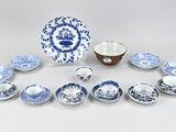 an assortment of blue and white plates and bowls on a table