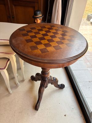une table sur laquelle est posé un échiquier, devant une fenêtre