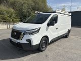 la camionnette blanche est garée sur un parking avec des arbres en arrière-plan