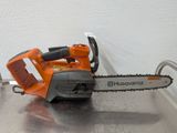 La tronçonneuse est posée sur la table, prête à l'emploi.