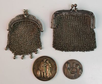 two silver metal purses and a coin on a white surface