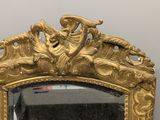 a mirror with a gold frame on the wall