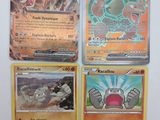 Quatre cartes Pokémon sont posées sur une table avec un fond blanc.