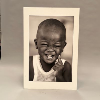 une photo en noir et blanc d'un petit garçon qui sourit