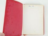 someone is holding a red book with a white page in it