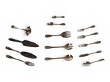 several forks and spoons are arranged in a circle on a white surface