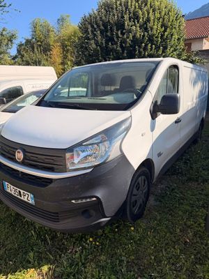 une camionnette blanche garée dans l'herbe à côté d'une autre camionnette blanche