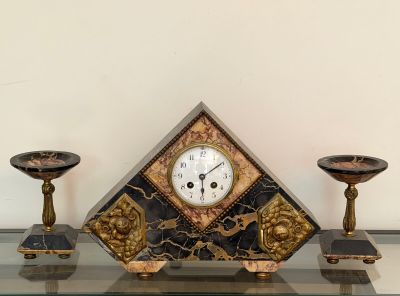 a clock sitting on top of a glass shelf next to two candles
