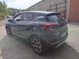 the rear end of a grey car parked in a parking lot