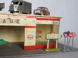 toy cars are parked in front of a gas station with a sign