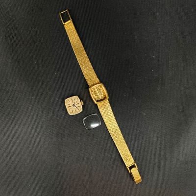 une montre en or et un bracelet en or sur un fond noir