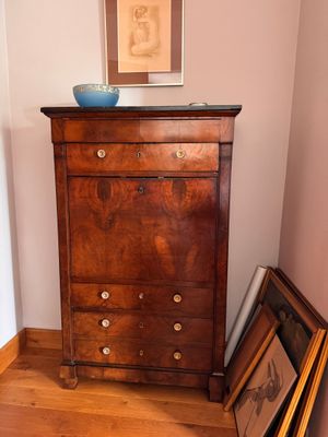 a dresser with a bowl on top of it in the corner of a room