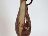 a brown vase with a black handle on a white background