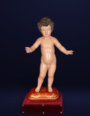 an image of a small statue of a boy standing on top of a red box