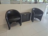two black chairs sitting next to each other in a room