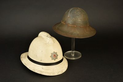 une paire de chapeaux et un porte-chapeaux posés sur une surface noire