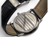 a close up of a watch on a black leather strap