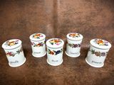 four white canisters with floral designs on them sitting on a brown surface